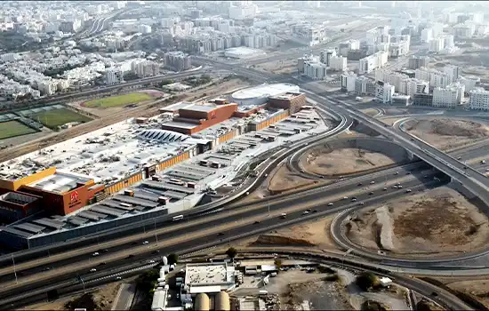 تصویری از عمان مال، بزرگ‌ترین مرکز خرید عمان، با چشم‌انداز هوایی از ساختمان و جاده‌های اطراف.